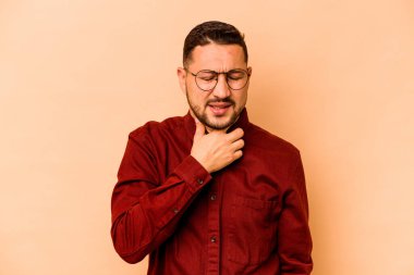 Bej arka planda izole edilmiş genç İspanyol bir adam virüs veya enfeksiyon yüzünden boğazında ağrı hissediyor..