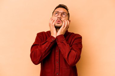 Latin kökenli genç adam bej arka planda yalnızdı sızlanıp ağlıyordu..