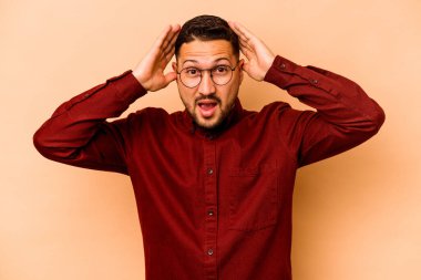 Genç İspanyol adam bej arka planda izole edilmiş bağırıyor, çok heyecanlı, tutkulu, bir şeyden memnun..