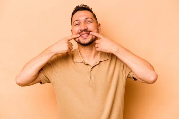 Mladý Hispánec Izolovaný Béžovém Pozadí Usmívá Ukazuje Prsty Ústa — Stock fotografie