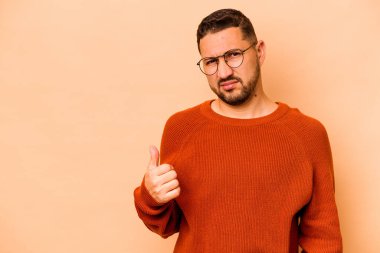 Latin kökenli genç adam bej arka planda izole edildi..