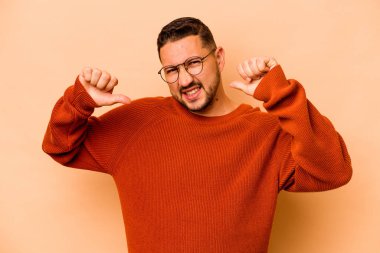 Bej arka planda izole edilmiş genç İspanyol adam gururlu ve kendinden emin hissediyor, örnek olarak.