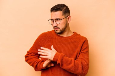 Latin kökenli genç bir adam bej arka planda izole edilmiş..