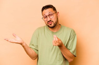 Latin kökenli genç bir adam bej arka planda izole edilmiş. Parası olmadığını gösteriyor..