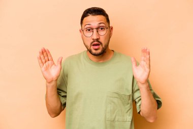 Latin kökenli genç bir adam bej arka planda izole edilmiş. Bir fikri var, ilham verici bir kavram..