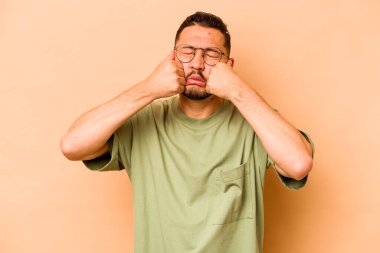 Latin kökenli genç adam bej arka planda yalnızdı sızlanıp ağlıyordu..