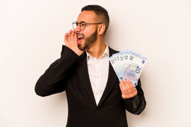 Beyaz arka planda izole edilmiş banknotlar tutan genç İspanyol bir adam bağırıyor ve avuç içi kadar açık bir ağız tutuyor..