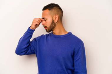 Beyaz arka planda izole edilmiş genç İspanyol bir adamın başı ağrıyor, yüzüne dokunuyor..