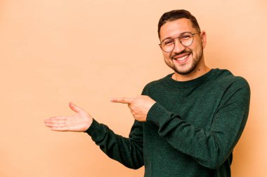 Latin kökenli genç, bej arka planda izole edilmiş..