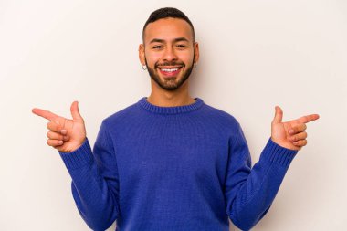 Beyaz arka planda izole edilmiş genç İspanyol adam farklı kopya alanlarını gösteriyor, birini seçiyor, parmaklarıyla gösteriyor..