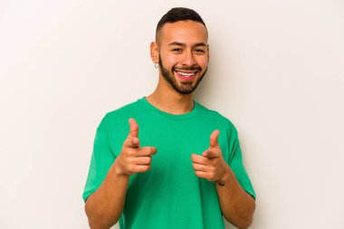 Beyaz arka planda izole edilmiş genç İspanyol adam parmaklarıyla ön tarafı işaret ediyor..