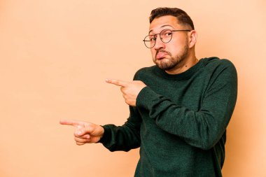 Latin kökenli genç adam bej arka planda izole edildi..