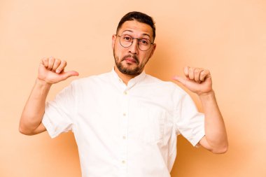 Bej arka planda izole edilmiş genç İspanyol adam gururlu ve kendinden emin hissediyor, örnek olarak.