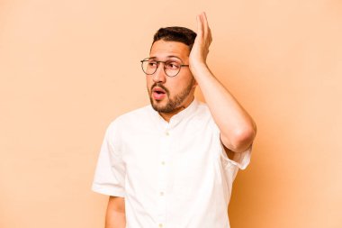 Latin kökenli genç bir adam, bej arka planda izole edilmişti..