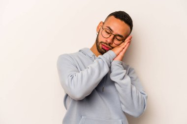 Beyaz arka planda izole edilmiş genç İspanyol adam esniyor. Ağzı eliyle kapatan yorgun bir hareket sergiliyor..