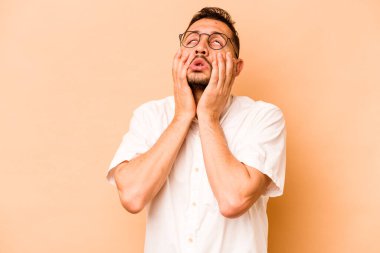 Latin kökenli genç adam bej arka planda yalnızdı sızlanıp ağlıyordu..