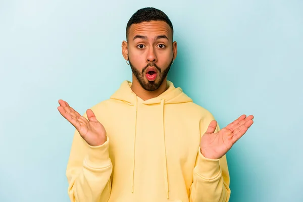 Joven Hispano Aislado Sobre Fondo Azul Sorprendido Sorprendido — Foto de Stock