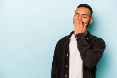 Genç İspanyol adam mavi arka planda izole edilmiş gülerek, kaygısızca, doğal duygularla.