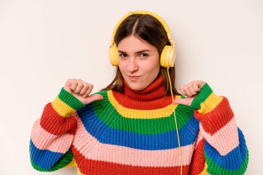 Beyaz arka planda izole edilmiş müzik dinleyen beyaz bir kadın kendini gururlu ve kendinden emin hissediyor..