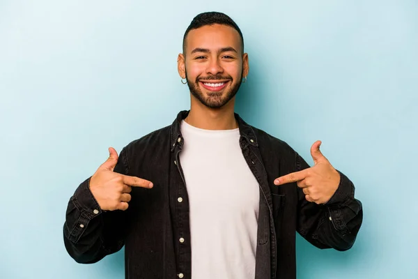 Mladý Hispánec Izolovaný Modrém Pozadí Ukazuje Prstem Dolů Pozitivní Pocit — Stock fotografie