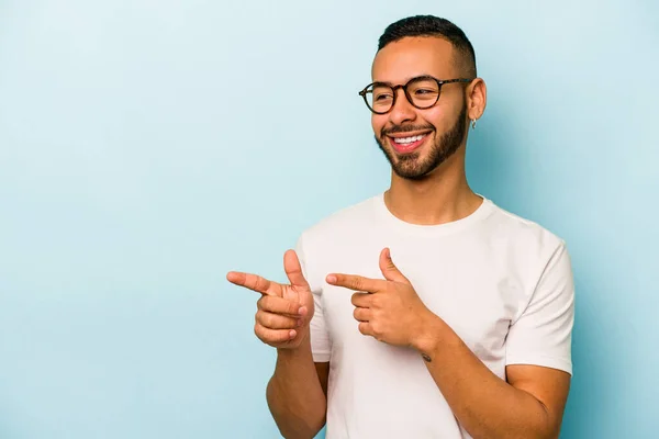 Jonge Spaanse Man Geïsoleerd Blauwe Achtergrond Punten Met Duim Vinger — Stockfoto