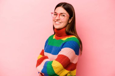 Pembe arka planda izole edilmiş genç beyaz kadın mutlu, güler yüzlü ve neşeli..