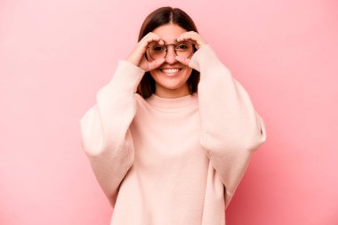 Pembe arka planda izole edilmiş beyaz bir kadın gözlerinde sorun olmadığını gösteriyor.