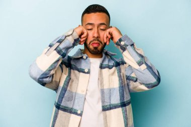 Genç İspanyol adam mavi arka planda yalnızdı sızlanıyor ve ağlıyordu..