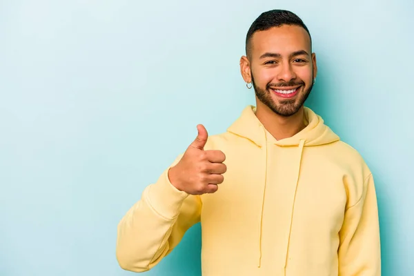 Jovem Hispânico Isolado Fundo Azul Sorrindo Levantando Polegar — Fotografia de Stock