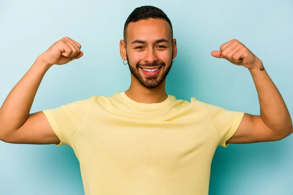 Young Hispanic Man Isolated Blue Background Showing Strength Gesture Arms — ストック写真