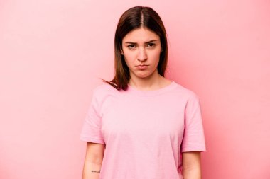Pembe arka planda soyutlanmış beyaz bir kadın üzgün, ciddi bir yüz, mutsuz ve hoşnutsuz..