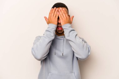 Beyaz arka planda izole edilmiş, yüzünün yarısını palmiye ile örterek eğlenen genç bir İspanyol..