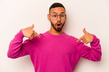 Beyaz arka planda izole edilmiş genç bir İspanyol. Parmakları aşağıda, olumlu hisler içinde..