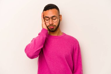 Beyaz arka planda izole edilmiş genç bir İspanyol. Çok yorgun ve uykulu. Elini başının üstünde tutuyor..