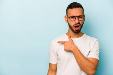 Mavi arka planda izole edilmiş genç bir İspanyol yan tarafı gösteriyor.