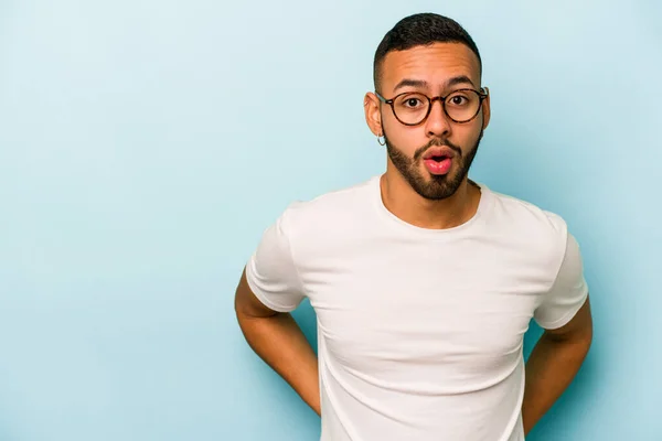 Joven Hombre Hispano Aislado Sobre Fondo Azul Siendo Sorprendido Por —  Fotos de Stock