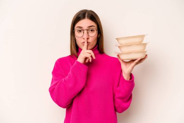 Beyaz arka planda bir sır saklayan ya da sessizlik isteyen beyaz tenli genç bir kadın..