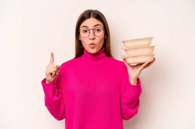 Beyaz arka planda saklanmış beyaz tencereli genç beyaz bir kadın harika bir fikri, yaratıcılık kavramı var..