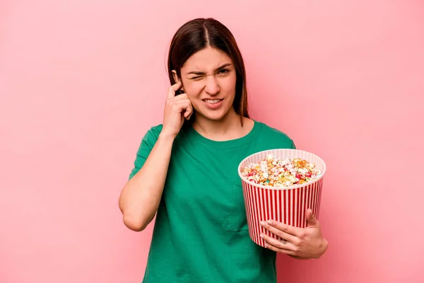 Jonge Kaukasische Vrouw Houden Popcorn Geïsoleerd Roze Achtergrond Bedekking Oren — Stockfoto
