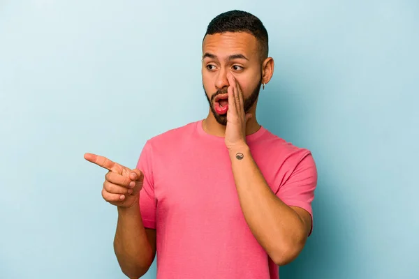 Young Hispanic Man Isolated Blue Background Saying Gossip Pointing Side — стоковое фото