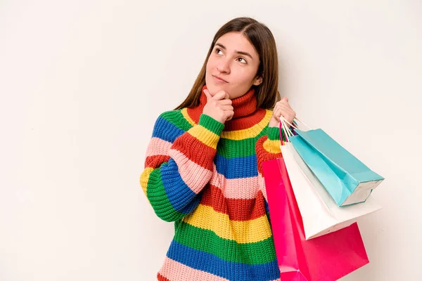 年轻的高加索女人带着怀疑和怀疑的表情 在白色背景下独自出去购物 — 图库照片