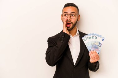 Beyaz arka planda izole edilmiş banknotları elinde tutan İspanyol genç adam gizli bir sıcak fren haberi veriyor ve kenara bakıyor.