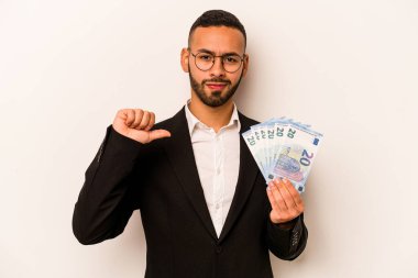 Beyaz arka planda soyutlanmış banknotları tutan Latin kökenli genç adam gururlu ve kendinden emin hissediyor, örnek olarak..