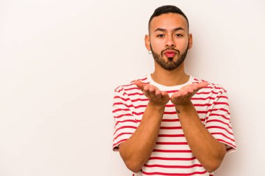 Beyaz arka planda izole edilmiş, dudakları kıvrılmış ve hava öpücüğü yollamak için avuç içi tutan İspanyol bir adam..