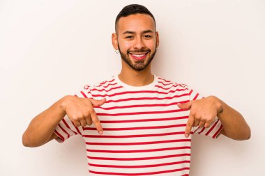 Beyaz arka planda izole edilmiş genç bir İspanyol. Parmakları aşağıda, olumlu hisler içinde..