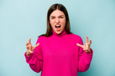 Mavi arka planda izole edilmiş beyaz bir kadın öfkeyle bağırıyor..