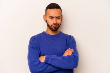 Beyaz arka planda izole edilmiş genç İspanyol adam alaycı bir ifadeyle kameraya bakıyor..