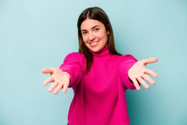 Mavi arka planda izole edilmiş beyaz bir kadın hoş bir ifade sergiliyor..