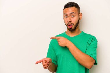 Beyaz arka planda izole edilmiş genç İspanyol adam işaret parmaklarıyla fotokopi alanını işaret ederek heyecan ve arzuyu ifade ediyor..