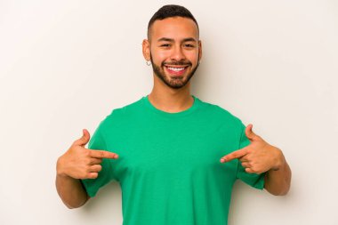 Beyaz arka planda izole edilmiş genç bir İspanyol. Parmakları aşağıda, olumlu hisler içinde..